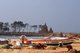 India: Fishing boats donated after the 2004 Indian Ocean tsunami lie on the beach at Mahabalipuram with the Shore Temple in the background, Tamil Nadu
